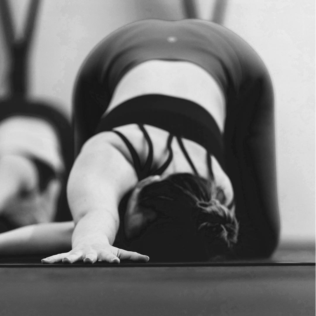 Schwarz-weißes Bild von einer Frau in Yogapose auf der Matte